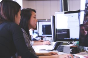 Imagem de duas mulheres olhando para o computador.